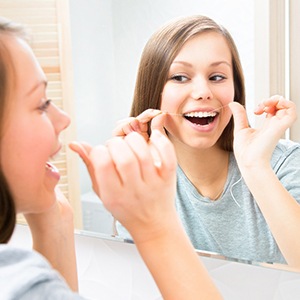 Woman flossing her teeth